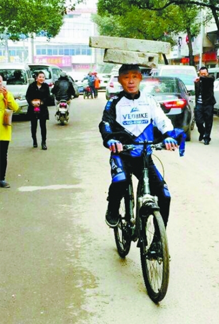 Ông Trương Huân Mộc vừa đội cối đá trên đầu, vừa đạp xe Ông Trương Huân Mộc vừa đội cối đá trên đầu, vừa đạp xe